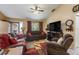 Cozy living room with comfortable sofas, a ceiling fan, and large windows, creating a welcoming atmosphere at 3210 Whitehorse Ct, Deltona, FL 32738