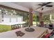 Enclosed brick porch with patio furniture and view of the detached garage at 3210 Whitehorse Ct, Deltona, FL 32738