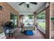 View of the enclosed patio with brick columns, ceiling fan, and outdoor seating at 3210 Whitehorse Ct, Deltona, FL 32738