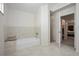Bright bathroom featuring a bathtub with a stone countertop, tiled walls, and an open shower at 3357 Black Willow Trl, Deland, FL 32724