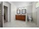 Bathroom with double vanity, mirrors, toilet, tiled floors, and a doorway that enters into another room at 3357 Black Willow Trl, Deland, FL 32724