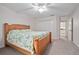 Bedroom featuring a ceiling fan, carpet, and bed with floral pattern comforter, with an open entry to bathroom at 3357 Black Willow Trl, Deland, FL 32724