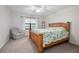 Bright bedroom with a large window, cozy chair, and a comfortable wooden bed with floral pattern comforter at 3357 Black Willow Trl, Deland, FL 32724