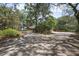 Expansive driveway leading to a beautiful home with mature trees and lush greenery at 3357 Black Willow Trl, Deland, FL 32724