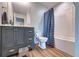 Bathroom featuring blue vanity, toilet, and a shower with curtain at 348 Southern Winds Blvd, Deland, FL 32720