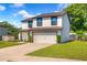 Traditional two-story home featuring an attached two-car garage and manicured front lawn at 348 Southern Winds Blvd, Deland, FL 32720