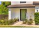Charming home entrance with a green door, welcome sign, and beautifully landscaped walkway at 348 Southern Winds Blvd, Deland, FL 32720