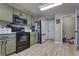 Sage-green kitchen cabinets, black appliances and a neutral color scheme create an inviting space at 348 Southern Winds Blvd, Deland, FL 32720