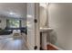 Stylish powder room with a pedestal sink, wood look floors, and view into the living room at 348 Southern Winds Blvd, Deland, FL 32720
