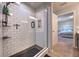 Clean, updated shower has white subway tiles and black hardware with a view into a bedroom at 348 Southern Winds Blvd, Deland, FL 32720
