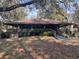 The exterior of the charming home features a spacious covered porch, surrounded by mature trees and natural beauty at 37 Meadowwood Trl, Deland, FL 32724