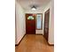 Bright foyer featuring wood flooring, dark wood door and trim, and natural light at 37 Meadowwood Trl, Deland, FL 32724