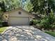 Charming home features a stone facade and well-manicured landscaping around a two car garage at 37 Meadowwood Trl, Deland, FL 32724