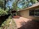 Back patio area with brick pavers, garden, and a red umbrella at 37 Meadowwood Trl, Deland, FL 32724