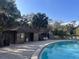A refreshing pool with a bathhouse and comfortable lounge chairs set among mature trees for ultimate relaxation at 37 Meadowwood Trl, Deland, FL 32724
