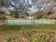 Well-maintained tennis courts surrounded by mature trees and landscaping, providing a scenic and active community amenity at 37 Meadowwood Trl, Deland, FL 32724