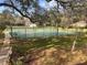 Two immaculately maintained tennis courts are nestled amidst mature trees and lush greenery, creating an idyllic setting at 37 Meadowwood Trl, Deland, FL 32724