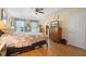 Bright bedroom featuring a ceiling fan, tray ceiling, and wood-look flooring at 4297 Regal Town Ln, Lake Mary, FL 32746