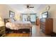 Bright bedroom featuring a ceiling fan, tray ceiling, and wood-look flooring at 4297 Regal Town Ln, Lake Mary, FL 32746