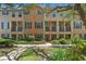 Inviting townhouse featuring a well-maintained lawn, dark shutters, and a covered front porch at 4297 Regal Town Ln, Lake Mary, FL 32746