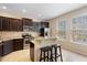 Kitchen featuring stainless appliances, granite countertops, dark cabinets, and a breakfast bar at 4297 Regal Town Ln, Lake Mary, FL 32746