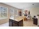 Kitchen island with granite countertop next to a dining area and large windows overlooking the yard at 4297 Regal Town Ln, Lake Mary, FL 32746