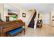 Features a piano, staircase, and entertainment setup with tiled floors at 4297 Regal Town Ln, Lake Mary, FL 32746