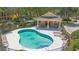 Community pool featuring lounge chairs, tables, and a small covered area, surrounded by lush greenery at 4297 Regal Town Ln, Lake Mary, FL 32746