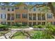 Inviting townhouse featuring a well-maintained lawn, dark shutters, and a covered front porch at 4297 Regal Town Ln, Lake Mary, FL 32746