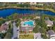 Aerial view of community pool with trees, lake, parking, and clubhouse at 518 Briarbrook Way, Deland, FL 32724
