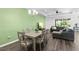 Dining room boasts a green accent wall, recessed lights, an elegant chandelier, and wood-look floors at 518 Briarbrook Way, Deland, FL 32724