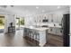 Modern kitchen featuring stainless steel appliances, a large island with seating, and light gray cabinetry at 518 Briarbrook Way, Deland, FL 32724
