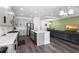 Open-concept kitchen and living room with stainless steel appliances, stone countertops, and modern furnishings at 518 Briarbrook Way, Deland, FL 32724