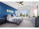 A spacious main bedroom with a tray ceiling, a blue accent wall, and a ceiling fan at 518 Briarbrook Way, Deland, FL 32724