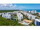 Scenic aerial view of beachfront condos, a community pool, and lush green landscaping at 5300 S Atlantic Ave # 12-403, New Smyrna Beach, FL 32169