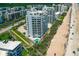 An aerial shot showcases a white condo on the beach with a pool, lawns and great views at 5300 S Atlantic Ave # 12-403, New Smyrna Beach, FL 32169