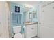 Nautical-themed bathroom with a granite countertop vanity, blue walls, and white cabinets at 5300 S Atlantic Ave # 12-403, New Smyrna Beach, FL 32169