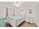 Bright bedroom featuring wood floors, a white bed frame, and coastal-themed decor at 5300 S Atlantic Ave # 12-403, New Smyrna Beach, FL 32169