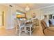 Dining room featuring a modern table set, chandelier, and an open kitchen view at 5300 S Atlantic Ave # 12-403, New Smyrna Beach, FL 32169