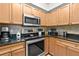 Close-up of kitchen featuring stainless steel oven, microwave, and cooktop with granite countertops at 5300 S Atlantic Ave # 12-403, New Smyrna Beach, FL 32169
