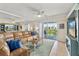 Cozy living room with sliding glass doors to the balcony, comfortable seating, and stylish decor at 5300 S Atlantic Ave # 12-403, New Smyrna Beach, FL 32169