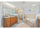 Bright bathroom featuring a glass enclosed shower, granite countertops, soaking tub, and double sinks at 5300 S Atlantic Ave # 12-403, New Smyrna Beach, FL 32169