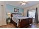 Bright bedroom featuring a bed, ceiling fan, and windows with curtains and a world map wall art at 5300 S Atlantic Ave # 12-403, New Smyrna Beach, FL 32169