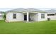 Lush backyard featuring a covered patio with outdoor seating and a well-manicured lawn at 5513 Estero Loop, Port Orange, FL 32128