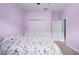 Bedroom with a patterned bedspread, closet doors and an interior door, with light purple walls at 5513 Estero Loop, Port Orange, FL 32128
