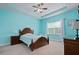 Bright bedroom with light blue walls, tray ceiling, a wooden bed frame and matching furniture at 5513 Estero Loop, Port Orange, FL 32128