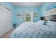 Bedroom with blue walls, carpeted floors, large window and a queen size bed with matching bedside tables at 5513 Estero Loop, Port Orange, FL 32128