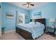 Bedroom with blue walls, carpeted floors, large window and a queen size bed with matching bedside tables at 5513 Estero Loop, Port Orange, FL 32128