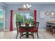 Cozy dining area featuring a round wood table set with red cushions and a view to the outdoors at 5513 Estero Loop, Port Orange, FL 32128