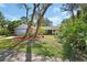 Landscaped front yard with a charming single-story home featuring a red front door and attached garage at 5967 Plantera Ct, Port Orange, FL 32127